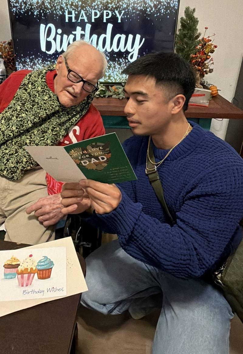 A resident reading a birthday card with a visitor