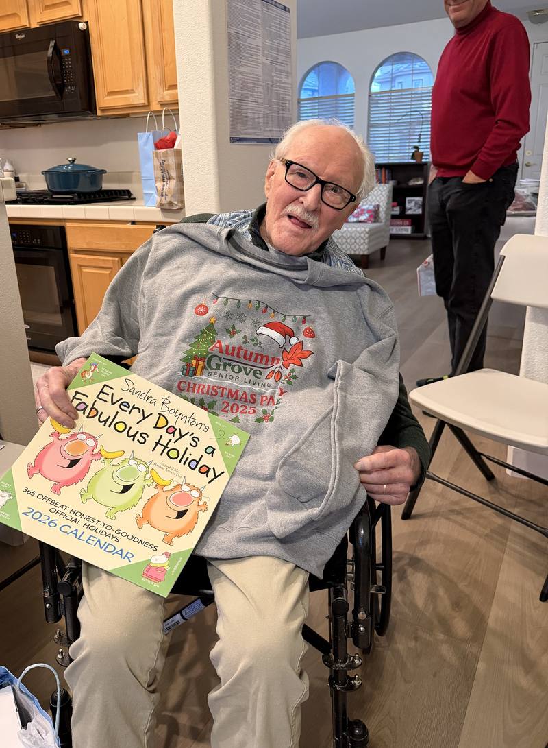 A resident showing his Autumn Grove Christmas party sweatshirt